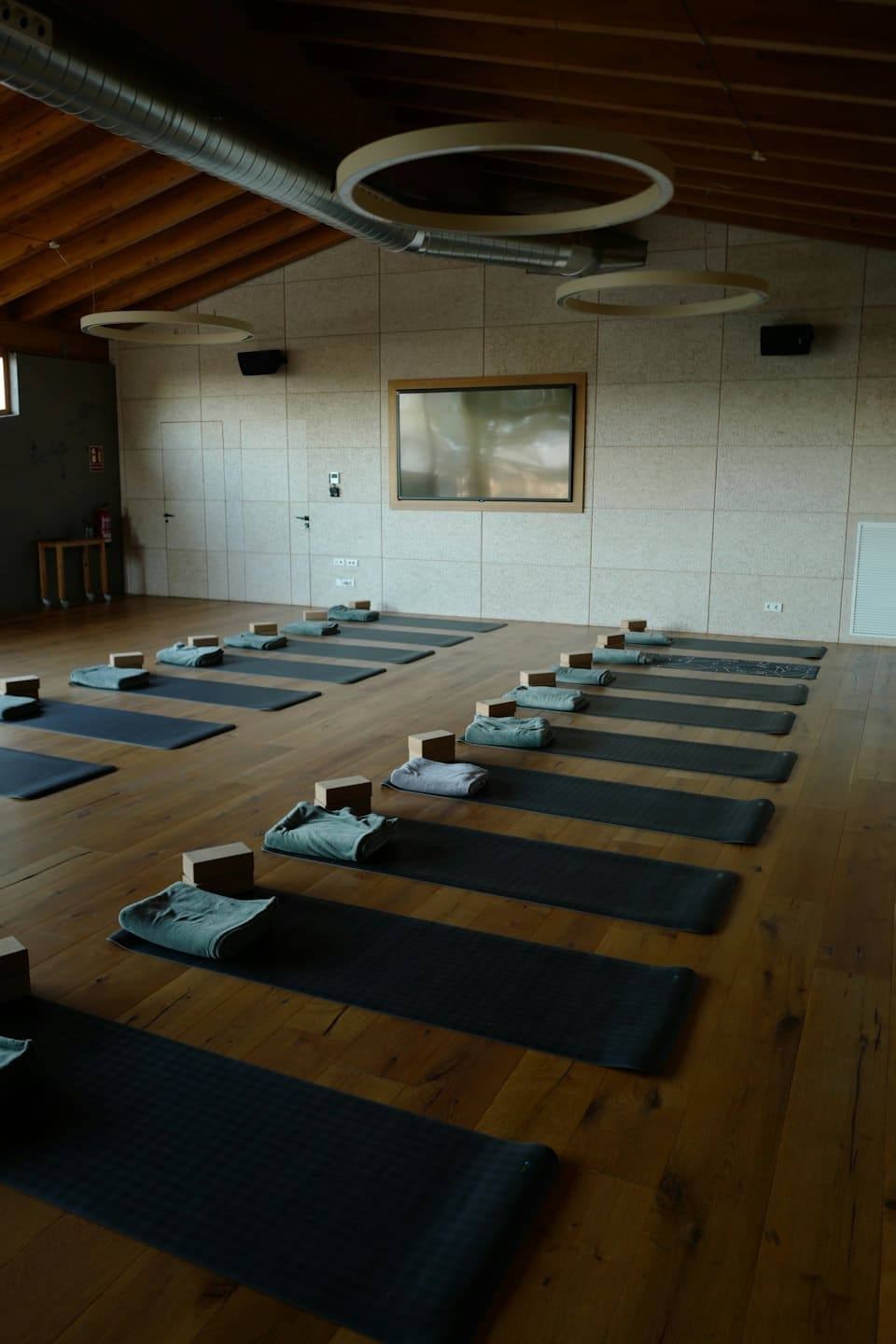 Yoga studio with mats, blocks, and towels arranged neatly.